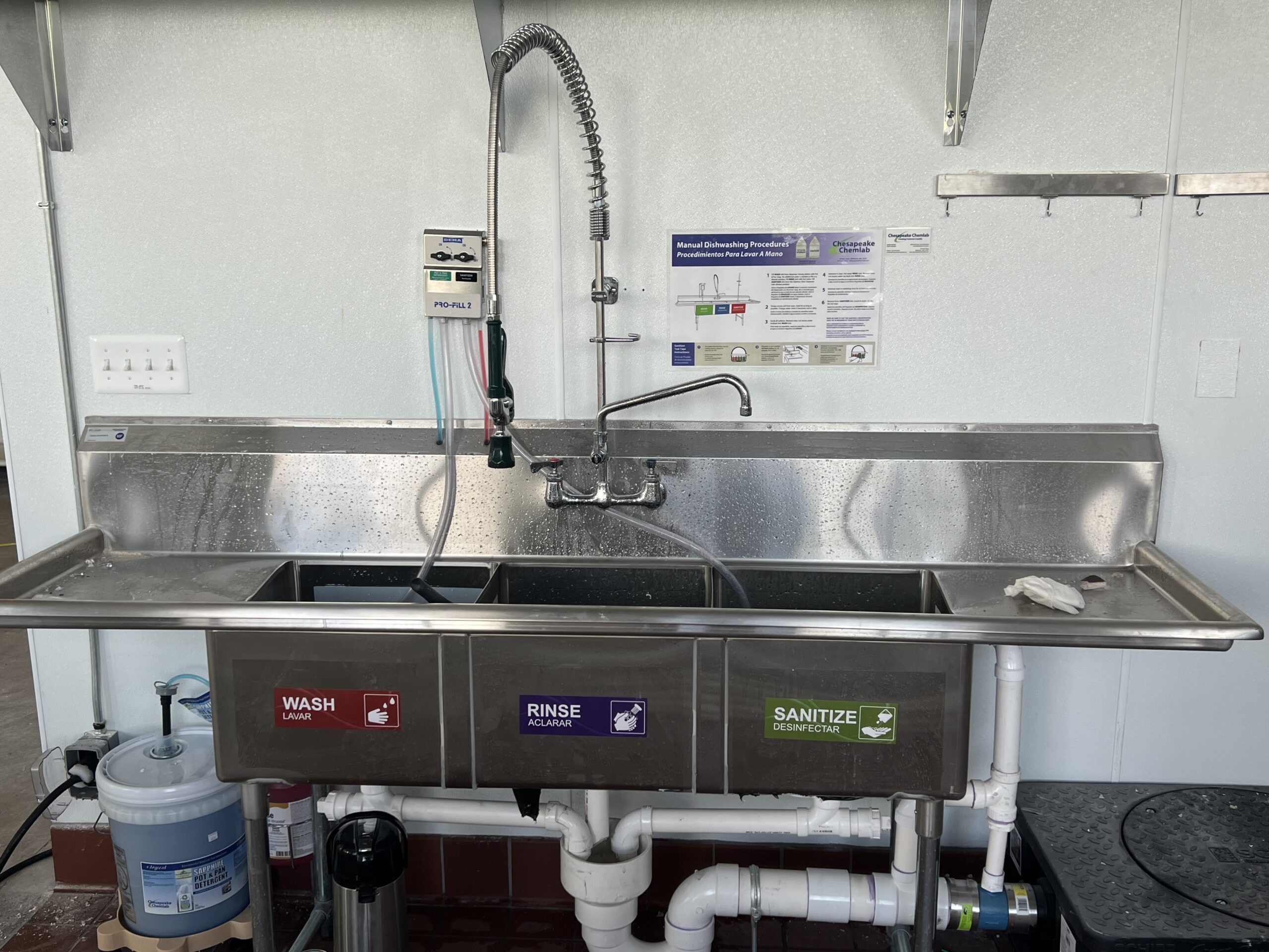 three-compartment sink, with pot and pan soap dispenser and quaternary sanitizer dispenser.